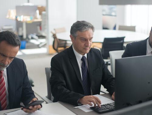 Três executivos na frente do computador